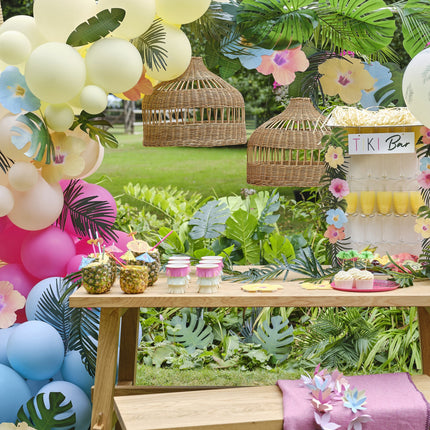 Arco di palloncini colorati con foglie e fiori