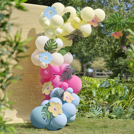 Arco di palloncini colorati con foglie e fiori